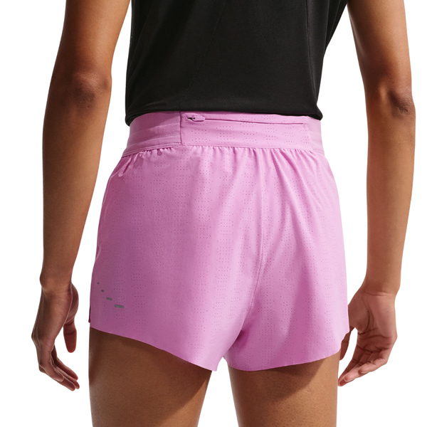 En person ses bagfra iført sort top og Nike Swift Breathe Mid-Rise 2.5" løbeshorts til damer i Lt Magenta/Photon Dust/Reflective Silv med lynlåslomme, perforerede detaljer og Dri-FIT-teknologi, der giver åndbarhed.