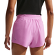 En person ses bagfra iført sort top og Nike Swift Breathe Mid-Rise 2.5" løbeshorts til damer i Lt Magenta/Photon Dust/Reflective Silv med lynlåslomme, perforerede detaljer og Dri-FIT-teknologi, der giver åndbarhed.