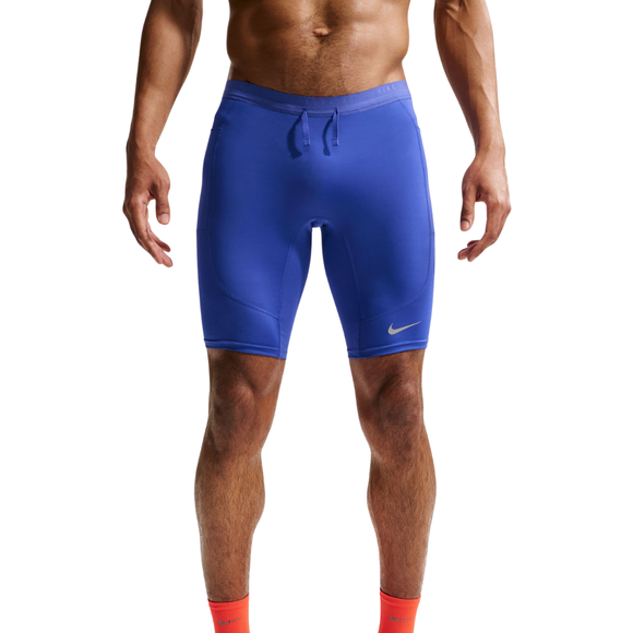 En person iført lyseblå Nike Stride Running Half Tights, Herre, Lapis/Reflective Silv og orange sokker står på en hvid baggrund. Billedet fremhæver underkroppen og benene. Med fugttransporterende Dri-FIT-teknologi.