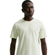 En herre modellerer Nike ACG Dri-FIT T-shirt i Sea Glass med et diskret logo på venstre bryst, mens han står på en hvid baggrund og kigger lidt til siden.