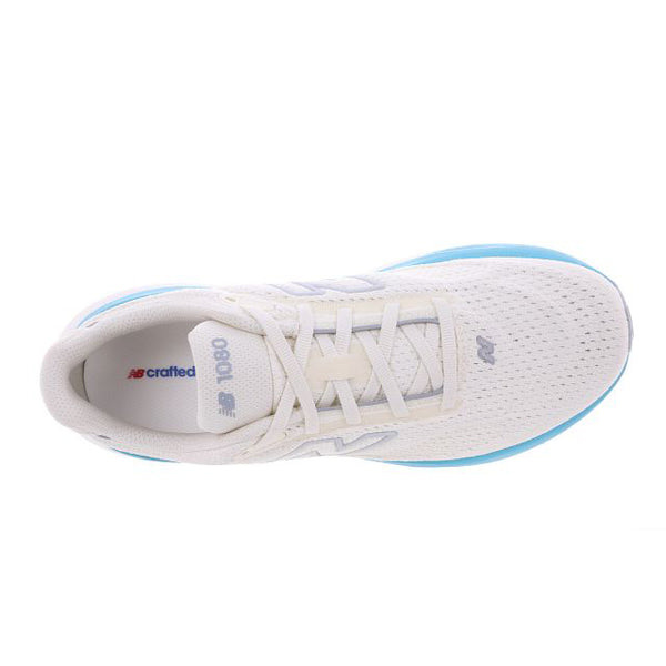 Ovenfra set billede af New Balance Infinion 1080 V15 Dame-løbeskoen i farven Angora, med hvidt mesh og lyseblå detaljer, »NB crafted« og »1080« på tungen samt stødabsorbering, der sikrer maksimal komfort på hver løbetur.