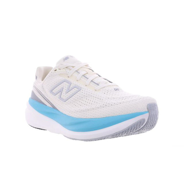 New Balance Infinion 1080 V15 Dame-løbesko i farven Angora har en hvid mesh-overdel med lyseblå og grå detaljer, snørelukning og en tyk, stødabsorberende sål, der sikrer maksimal komfort. Skoen er fotograferet på en hvid baggrund.