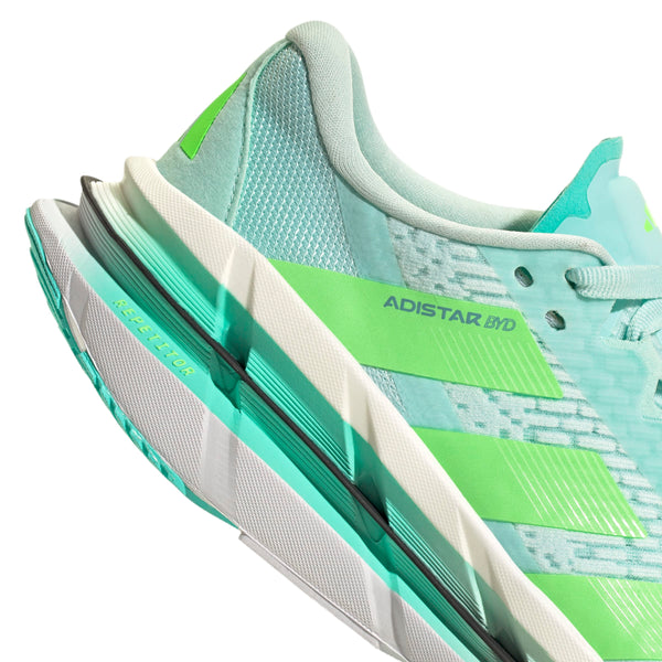 Nærbillede af en lyseblå og grøn Adidas Adistar Byd Dame løbesko i Halmin/Limbur/Flaaqu, der viser sideprofilen, overdelen i mesh, ADISTAR BYD-teksten og den lagdelte sål med gul RESISTA-detalje.