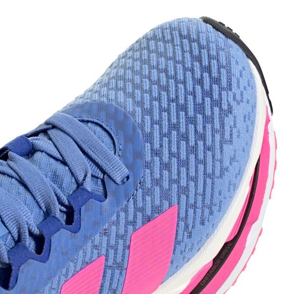 Nærbillede af tåen og siden på Adidas Adistar Byd løbesko dame i Blufus/Lucpnk/Lucblu, med struktureret stof, pink detaljer, blå snørebånd og en hvid-pink sål for komfort med en sort ydersåldel for stabilitet.