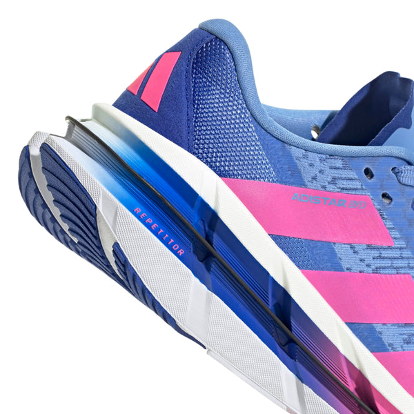 Nærbillede af Adidas Adistar Byd Dame i Blufus/Lucpnk/Lucblu med pink striber, en struktureret sål med REPETITOR på mellemsålen, en åndbar overdel i mesh og et pink geometrisk hældesign.