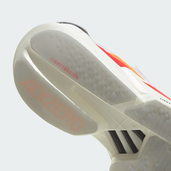 Nærbillede af sålen på Adidas Adizero Adios Pro 4 til mænd i Cloud White/Lucid Orange/Lucid Red med ADIZERO og LIGHTTRAXION-tekst, strukturerede grebsmønstre og orange accenter.