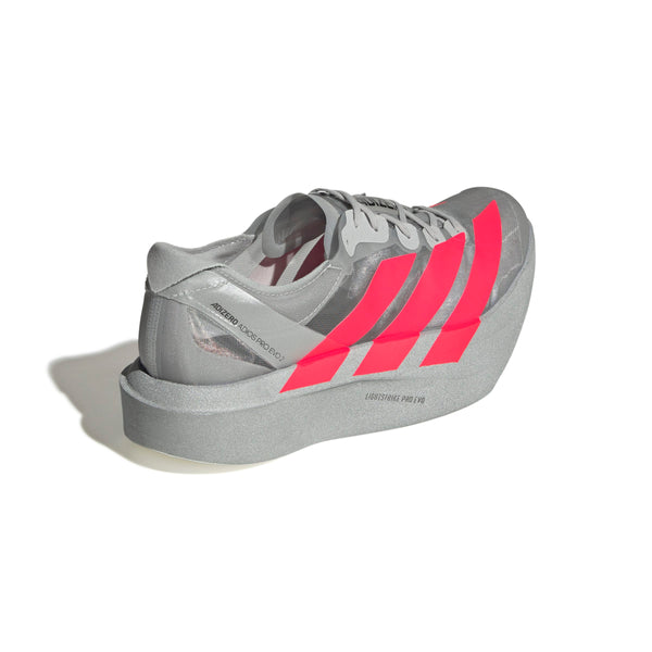 Adidas Pro Evo 2 Unisex-sneakeren i Silver Metallic/Lucid Red/Grey Two har en overdrevet, tyk LIGHTSTRIKE PRO-mellemsål, en gennemsigtig sektion og et futuristisk maratoninspireret design mod en hvid baggrund.