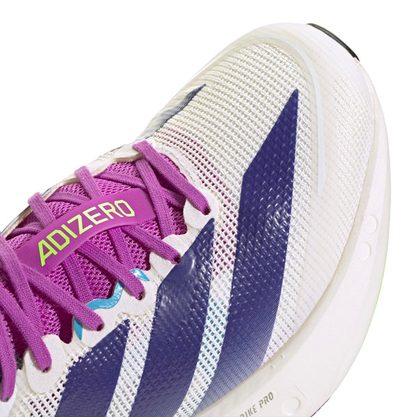 Nærbillede af Adidas Adizero Boston 13 Dame løbesko i Cwhite/Cpurpl/Limbur, der viser lilla striber og snørebånd, et grønt ADIZERO-mærke nær tungen, overdel i mesh og synlige syningsdetaljer.