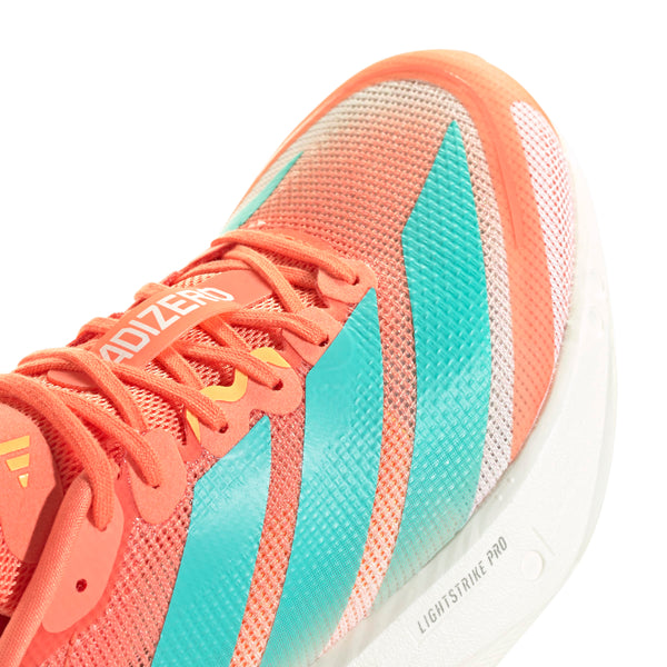 Nærbillede af Adidas Adizero Boston 13 Dame i Semcor/Flaaqu/Flaora med koralfarvet overdel, turkise og hvide striber, orange snørebånd og en hvid Lightstrike Pro-sål. ADIZERO-mærket er tæt på tungen.