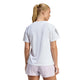 En kvinde med blondt hår i hestehale ses bagfra iført Adidas Adi365 Running Tee, Dame, White og lyserøde shorts - ideel til løbetræning - mod en almindelig hvid baggrund.