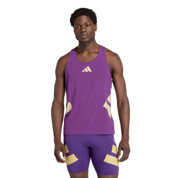 En mand kigger fremad mod en hvid baggrund iført Adidas Rtr Singlet, Herre, Violet - en lilla ærmeløs sportstop med matchende shorts med lysegule geometriske detaljer.