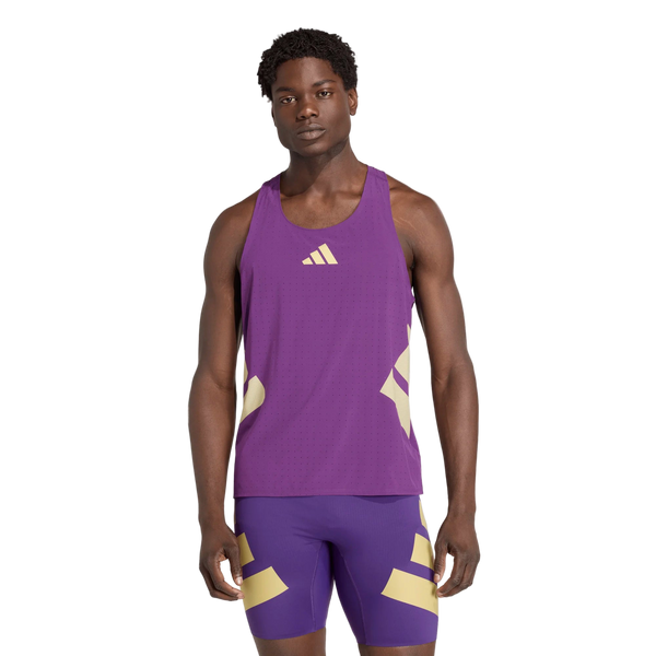 En mand kigger fremad mod en hvid baggrund iført Adidas Rtr Singlet, Herre, Violet - en lilla ærmeløs sportstop med matchende shorts med lysegule geometriske detaljer.