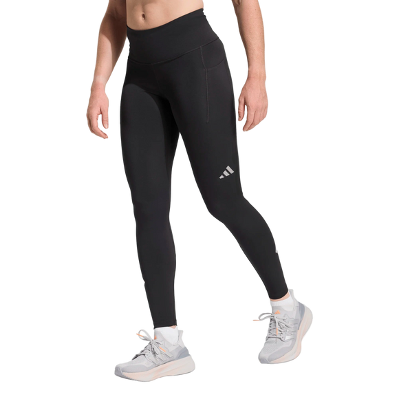 En person iført Adidas Adi365 3S 1/1 Leggings til kvinder i sort, parret med hvide sportssokker og hvide sneakers med grå såler, står på en hvid baggrund.