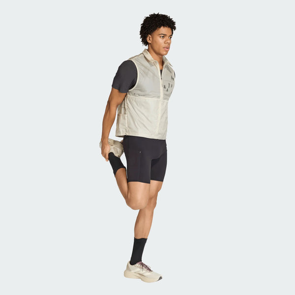 En person iført Adidas Adi365 Hk Tight til mænd i sort balancerer på det ene ben, strækker det andet bagud og holder anklen med den ene hånd.