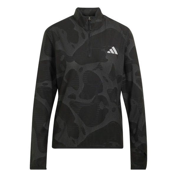Adidas Adi365 Running Half Zip til kvinder i farven Black/Grefiv er en langærmet sportsbluse med en kvart-lynlås i kraven, diskrete abstrakte mønstre og et diskret hvidt Adidas-logo på venstre bryst. Denne løbetrøje til kvinder er designet med climawarm+ teknologi for øget komfort under dine løbeture og fremviser en blanding af lyse og mørke nuancer, der giver ekstra visuel tekstur.