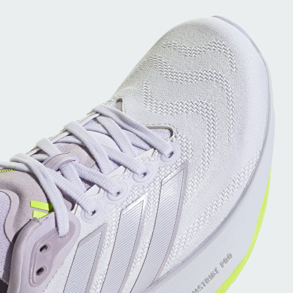 Nærbillede af tåen og snørebåndene på en hvid Adidas Supernova Prima 3 dame-løbesko med lyselilla (Fropur) detaljer, struktureret stof og en lysegul (Hireye) kant langs sålen. Den øverste del af denne mængdetræningssko er prydet med diskrete mønstrede syninger.