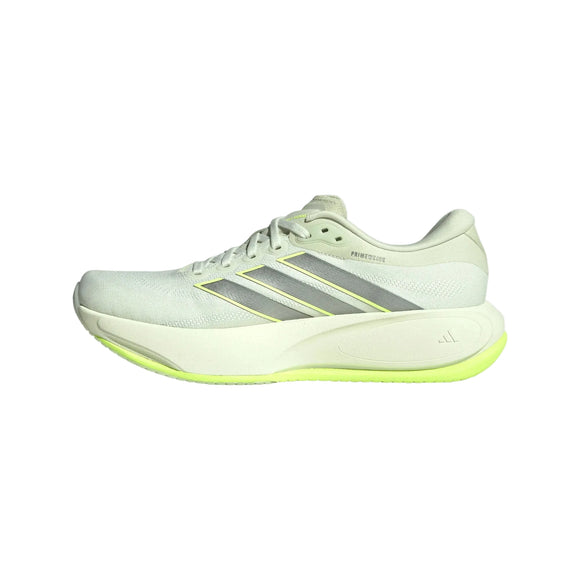 Et billede set fra siden af den lysegrå Adidas Supernova Prima 3, Herre, Cryjad/Ironmt/Siggnr løbesko med tre sølvstriber og en tyk hvid sål med en gul detalje langs underkanten, designet til blød støddæmpning på hver eneste løbetur.