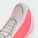 Nærbillede af et par Adidas Hyperboost Edge Dame (Hyperw/Soltur/Soltur) løbesko i hvid og lyserød med grå detaljer, med snørebånd, en overdel i åndbart mesh og detaljerede syninger på tåen og siden; set ovenfra på en lys baggrund – ideel til komfortfokuseret vejløb.