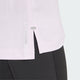 Nærbillede af undersiden af den lyserøde Adidas Adi365 Running Tee (Dame, Icelav) med en lille slids i siden og logo, sat sammen med sorte atletiske leggings.