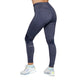 En person er iført mørkeblå Kari Traa Julie High Waist Tight, Dame, Marin leggings med KARI TRAA-logo på venstre underben og hvide sko med lyseblå og gule detaljer, stående på en hvid baggrund.
