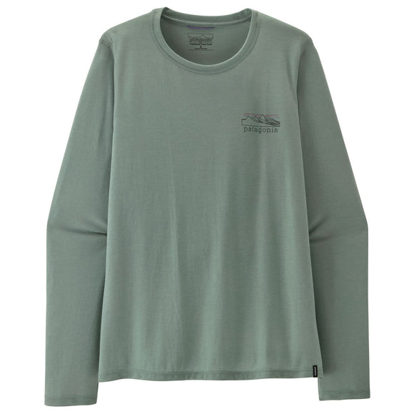 En Patagonia L/S Cap Cool Trail-trøje – Stratapeaks til kvinder i farven Cover Green, med et lille Patagonia-logo og et bjergmotiv på venstre bryst, ligger fladt ud på en hvid baggrund. Denne svedtransporterende trøje har et klassisk design med lange ærmer og rund hals.