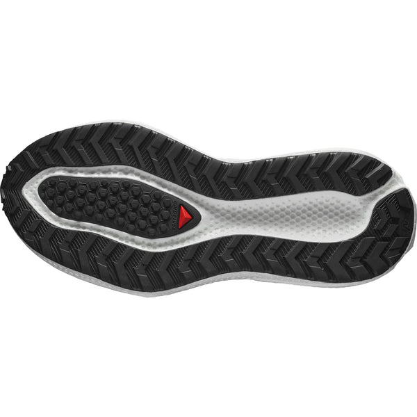 Billedet viser undersiden af en Salomon Aero Glide 3 GRVL Dame-sål i White/Ftw Silver/Green Gecko med et sort og hvidt zigzag-mønster og en lille rød trekant, der giver greb.