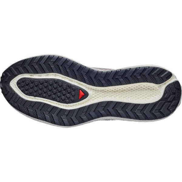 Billedet viser undersiden af Salomon Aero Glide 4 Grvl, Herre (Vanilla Ice/Black/Iron) løbesko med en sort og hvid sekskantet slidbane, røde trekantsdetaljer og et design, der giver maksimal komfort.