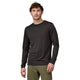 En mand med kort brunt hår, iført Patagonia L/S Cap Cool Merino Shirt, Herre, Black og olivengrønne bukser, står på en almindelig lys baggrund og kigger ind i kameraet med et neutralt udtryk.