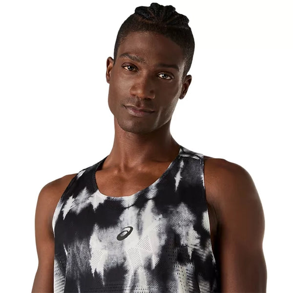 En mand med flettet hår bærer ASICS’ Limited Series Metarun Singlet, Herre i farven Cream/Performance Black, der er prydet med det ikoniske ASICS-logo på brystet og designet til optimal ydeevne med ACTIBREEZE-teknologi. Han står foran en ensfarvet hvid baggrund, hvilket fremhæver denne løbesinglet til mænd – et ideelt valg for løbere, der værdsætter både komfort og stil.