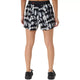 En person står med ryggen til, iført sorte sneakers og ASICS Limited Series Metarun Split Shorts til kvinder i farvekombinationen Cream/Performance Black – et stilfuldt par løbeshorts til kvinder med et sort-hvidt tie-dye-mønster og en kontrastfarvet sort linning. Hænderne hviler ned langs siden på en ensfarvet hvid baggrund.
