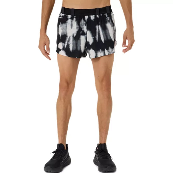 En person iført cremefarvede og sorte »Performance Black« Limited Series Metarun Split-shorts til mænd fra Asics samt sorte sneakers står med ansigtet vendt fremad foran en ensfarvet hvid baggrund.