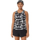 En person står og smiler iført en Asics Limited Series Metarun Tank til kvinder i farvekombinationen Cream/Performance Black med ACTIBREEZE-teknologi, en matchende kasket og sorte sportsshorts. Baggrunden er ensfarvet hvid.
