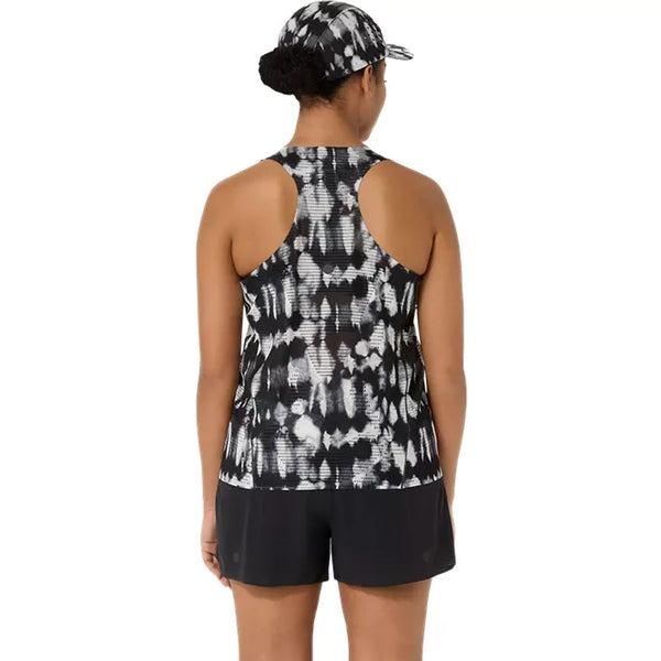 Der ses en person set bagfra, der bærer Asics Limited Series Metarun Tank til kvinder i farvekombinationen Cream/Performance Black, som er udstyret med ACTIBREEZE-teknologi. Outfitet suppleres af sorte sportsshorts og en matchende ASICS-kasket med mønster, og håret er sat op i en lav knold.