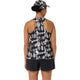 Der ses en person set bagfra, der bærer Asics Limited Series Metarun Tank til kvinder i farvekombinationen Cream/Performance Black, som er udstyret med ACTIBREEZE-teknologi. Outfitet suppleres af sorte sportsshorts og en matchende ASICS-kasket med mønster, og håret er sat op i en lav knold.