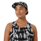 En kvinde iført ASICS’ Limited Series Metarun Tank i farvekombinationen Cream/Performance Black, udstyret med ACTIBREEZE-teknologi, samt en matchende kasket, kigger let til siden og smiler foran en ensfarvet hvid baggrund.