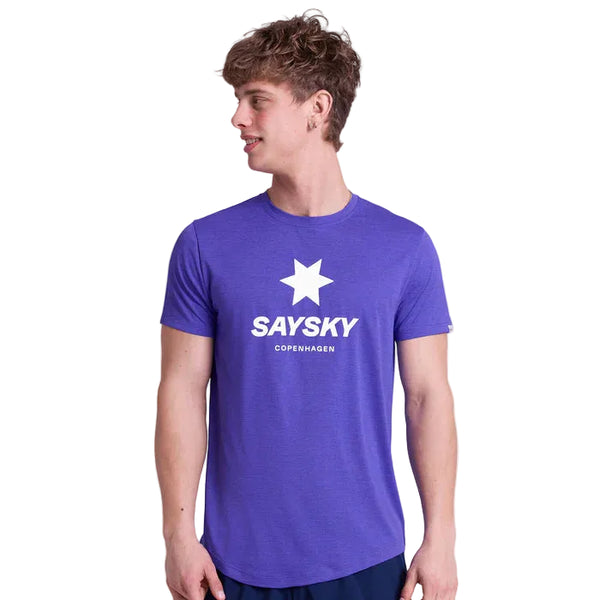 En ung mand iført Saysky Logo Combat Pro T-shirt, Herre, Purple med en hvid stjerne og SAYSKY COPENHAGEN-tekst på forsiden står og kigger til venstre mod en almindelig hvid baggrund.