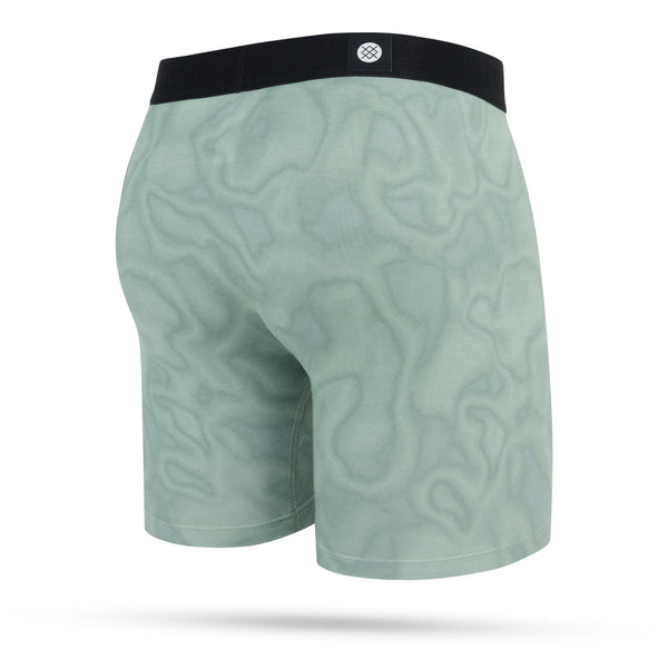 Stance Solid Green Wholester herre boxershorts har en lysegrøn farve, bølget mønster, sort linning og et centreret cirkulært logo på bagsiden. Vises mod en hvid baggrund.