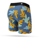 Stance In Paradise Wholester boxershortsene her har et flerfarvet bladmønster med blå, gule og lyseblå toner plus en sort linning, der vises stilfuldt mod en hvid baggrund.