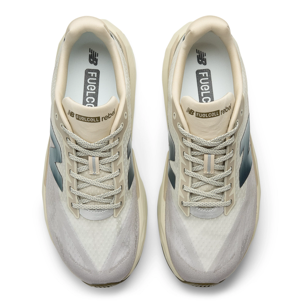 En top-down-visning af New Balance Fuelcell Rebel V5, Herre, Dream State-træningssko i beige og hvid, der fremhæver snørebånd, mesh-overdel og logodetaljer - perfekt til tempotræning.