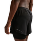 En mand er iført Nike Stride 5" Hybrid Running Shorts (Herre) i Black/Reflective Silver, der har et tætsiddende inderlag og et ventileret yderlag, set bagfra og fra siden på en hvid baggrund - perfekt til et svedtransporterende løb.