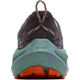 Et nærbillede forfra af Brooks Ghost Trail Dame-løbeskoen i farvekombinationen Shark/Jade/Orange, med en grå overdel, en grøn og lilla plettet mellemsål med »GHOST« præget ind i materialet samt en orange ydersål. Skoen står oprejst med snørebåndene bundet i en løkke øverst.