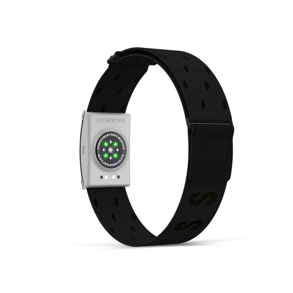 COROS-pulsmåleren, Jakob Ingebrigtsen Edition, har et sort armbånd med diskrete mønstre, en velcrolukning og en rektangulær hvid sensor med runde grønne LED’er – perfekt til sportsudøvere.