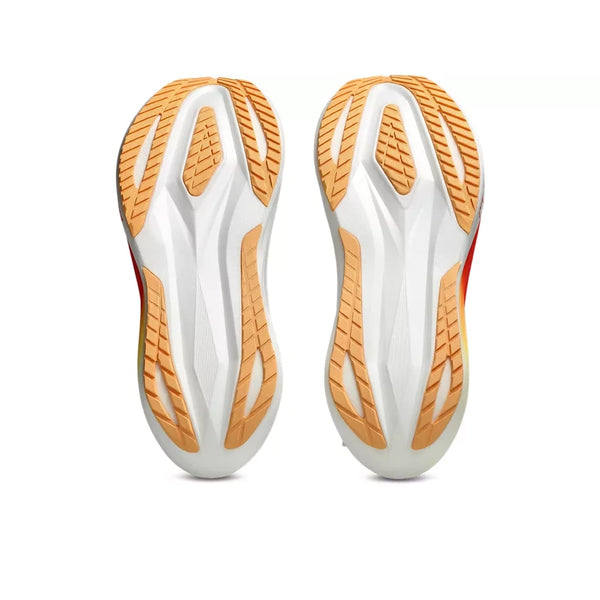 Undersiden af to ASICS Megablast unisex-løbesko i farvekombinationen White/Orange Glow, med hvid base og lysebrunt gummisålmønster med geometriske mønstre, der sikrer greb og vejgreb, vist på en ensfarvet hvid baggrund. Disse sko er udviklet med det innovative FF TURBO SQUARED-skum og giver maksimal affjedring for forbedret ydeevne.