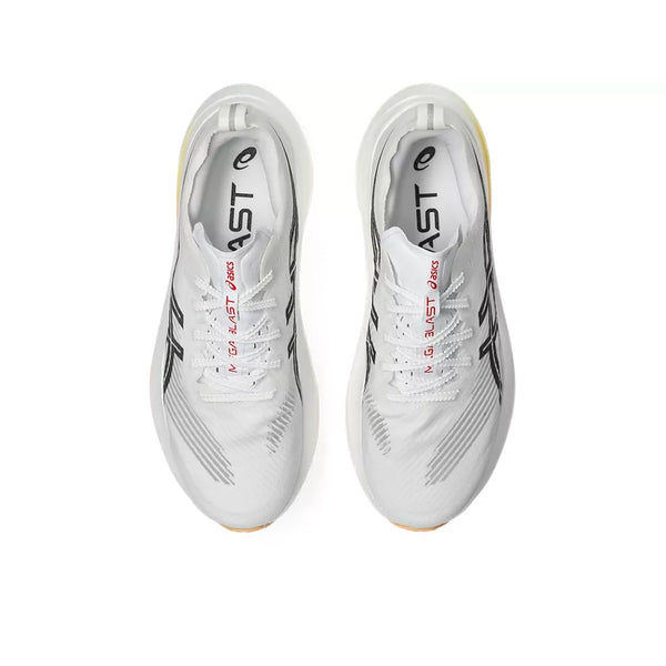 Et par hvide/orange ASICS Megablast unisex-løbesko med selvlysende effekt set ovenfra, med sorte og grå detaljer, snørebånd og ordet »BLAST« trykt på tungen sammen med Asics-logoet. Disse sko er designet til maksimal affjedring takket være det innovative FF TURBO SQUARED-skum og præsenteres her på en ensfarvet hvid baggrund.