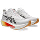 Et par hvide ASICS Megablast unisex-løbesko i farvekombinationen White/Orange Glow, med sorte ASICS-logoer, orange og gule farveovergange på mellemsålen, ydersåler af gummi samt en markant rød »FF TURBO SQUARED skum«-tekst på siden. Skoene er designet til maksimal affjedring og er vinklet, så både siden og fronten kommer til sin ret.