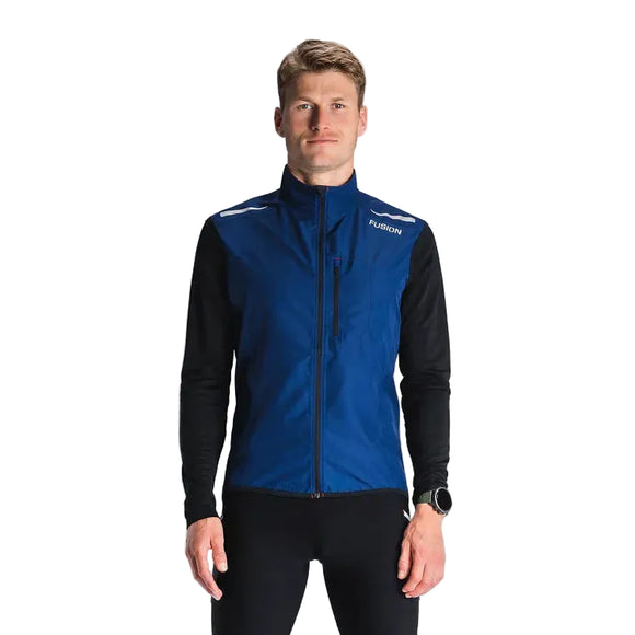 En mand ser frem for sig iført Fusion S1 Run Vest, Herre i Night Blue over en sort langærmet skjorte og sorte bukser, med et ur på venstre håndled. Baggrunden er ensfarvet og lys.