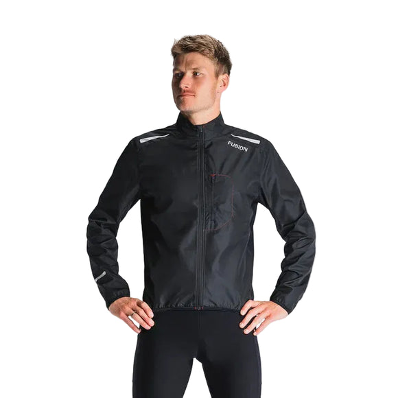 En mand står med hænderne på hofterne iført Fusion S1 Run Jacket til mænd i sort med refleksstriber på skuldrene og ved håndleddene. Jakken viser "FUSION" på brystet mod en almindelig lysegrå baggrund.