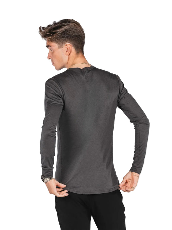 En mand set bagfra iført en Fusion Merino 150 LS, Herre, grå langærmet skjorte og sorte bukser.