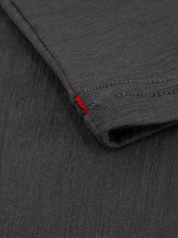 Nærbillede af manchetten på en grå Merino 150 LS, Herre, grå langærmet skjorte med en lille rød syet detalje.