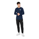 En mand iført en marineblå SAYSKY Merino Base 165 langærmet trøje, sorte joggingbukser og hvide sneakers.